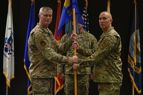 U.S. Air Force Col. Tony England, 17th Mission Support Group commander, passes the guidon to Capt. Heath Turley, incoming 17th Security Forces Squadron commander, during the change of command ceremony at the Event Center on Goodfellow Air Force Base, Texas, June 22, 2021. Turley was previously the antiterrorism action officer for the U.S. European Command in Germany. (U.S. Air Force photo by Senior Airman Ashley Thrash)