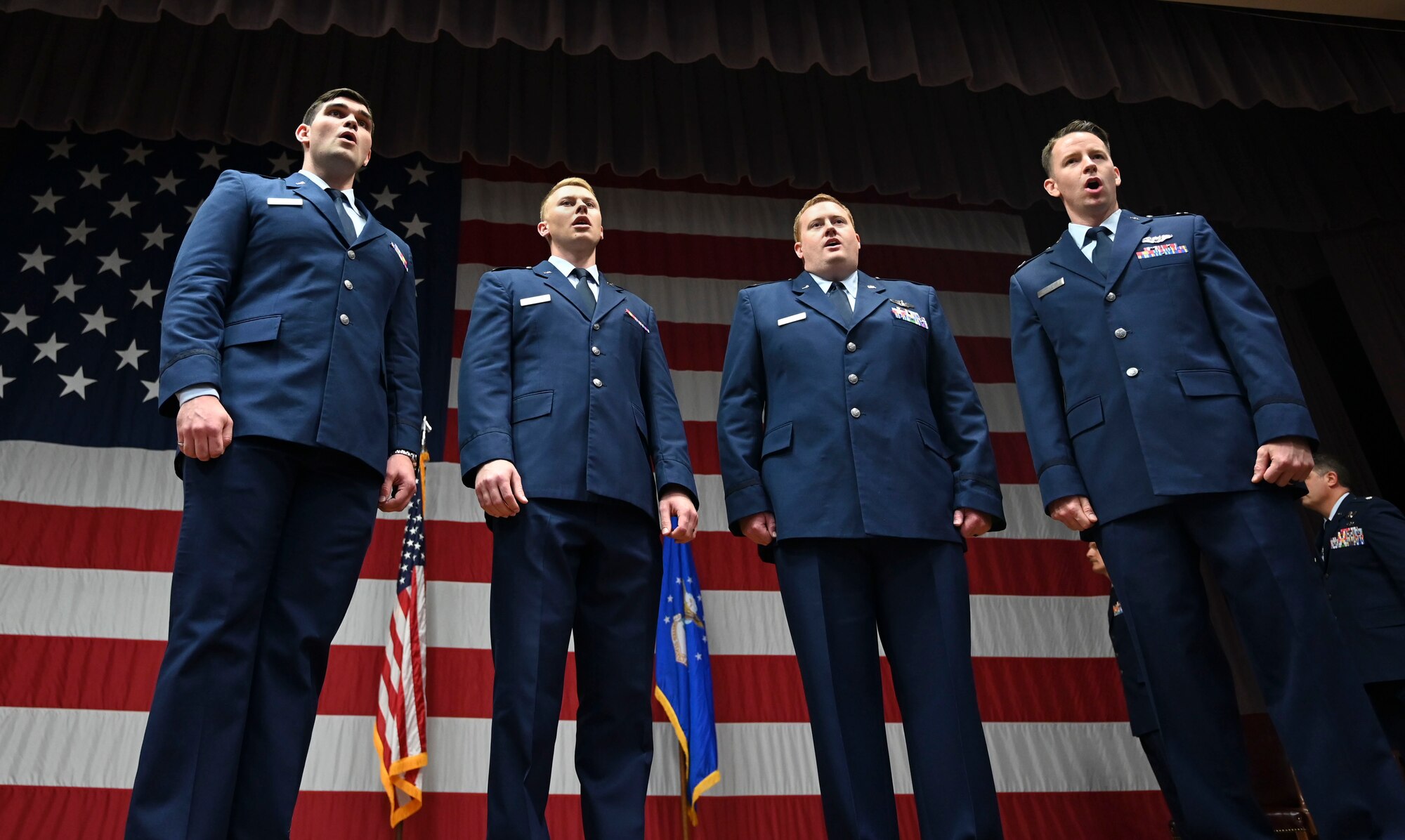 A choir comprised of two instructor pilots and two student pilots assigned to the 14th Flying Training Wing, preform the National Anthem during a change of command ceremony, June 21, 2021, on Columbus Air Force Base, Miss. The mission of the 14th Student Squadron is to ensure student pilots have everything they need to become both officers and pilots while providing unrivaled academic and simulator training. (U.S. Air Force photo by Airman 1st Class Jessica Haynie)