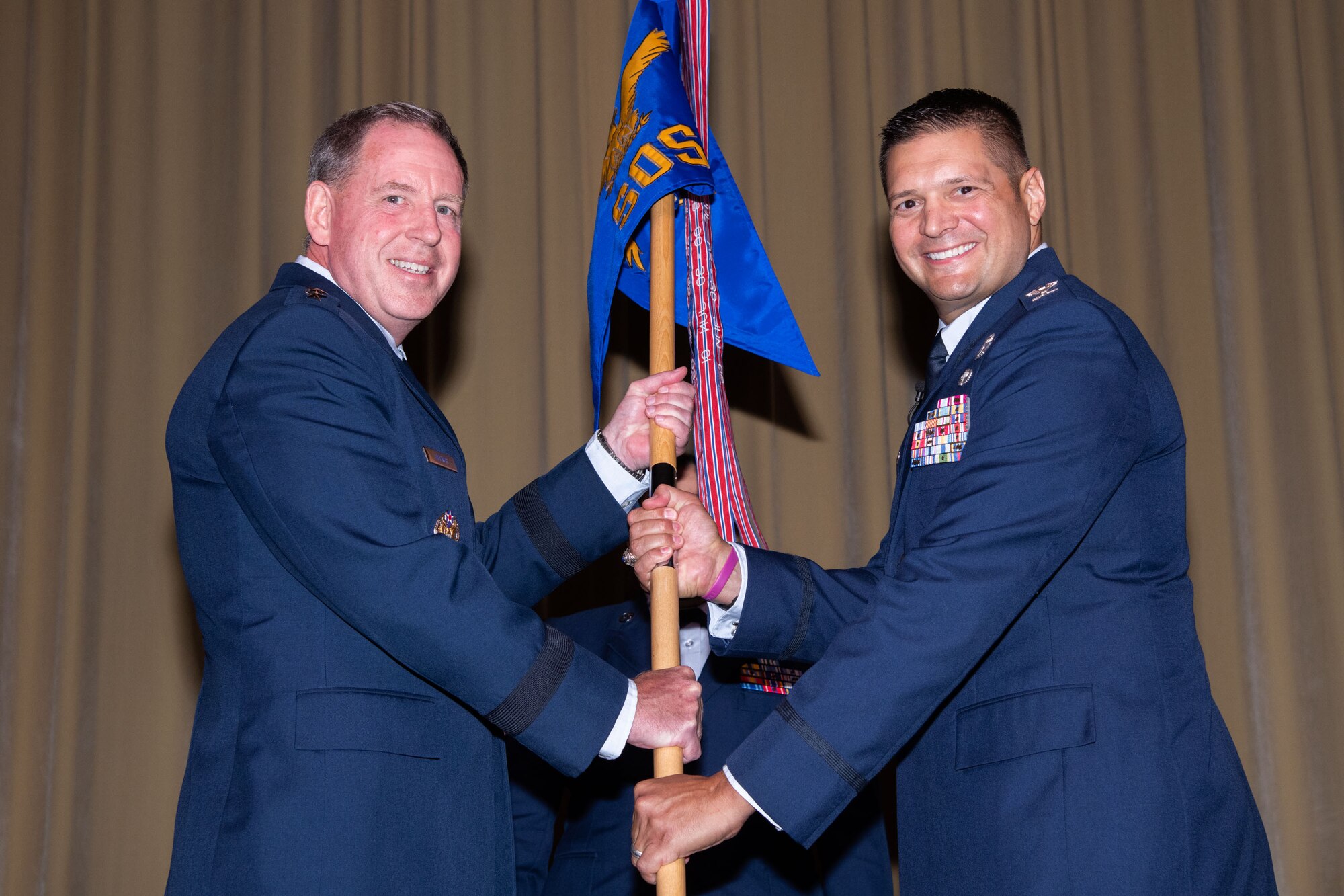 Maxwell AFB, Ala. - Lt Gen James Hecker commander and president, passes the unit guidon to incoming Squadron Officer School Commander Col. Lance Rosa-Miranda at the SOS Assumption of Command Ceremony held June 21, 2021, at Maxwell Air Force Base, Alabama. (U.S. Air Force photo by William Birchfield)