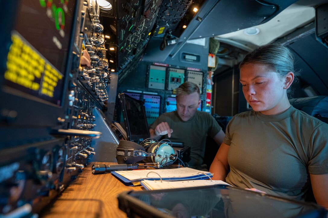 Staff Sgt. Justin Thomas, left, 9th Airlift Squadron noncommissioned officer in charge of loadmaster training, instructs Airman 1st Class Rebecca Reimer, 9th AS student loadmaster, on proper power up procedures for the auxiliary power units of a Dover Air Force Base C-5M Super Galaxy during a Major Command Service Tail Trainer at Holloman AFB, New Mexico, June 8, 2021. The 9th AS performs MSTTs to expedite upgrade and qualification training for C-5M loadmasters and flight engineers. Of the 350 tasks needed to be a fully qualified loadmaster, roughly half can be completed during an MSTT, reducing training time by up to 35 days. (U.S. Air Force photo by Senior Airman Faith Schaefer)