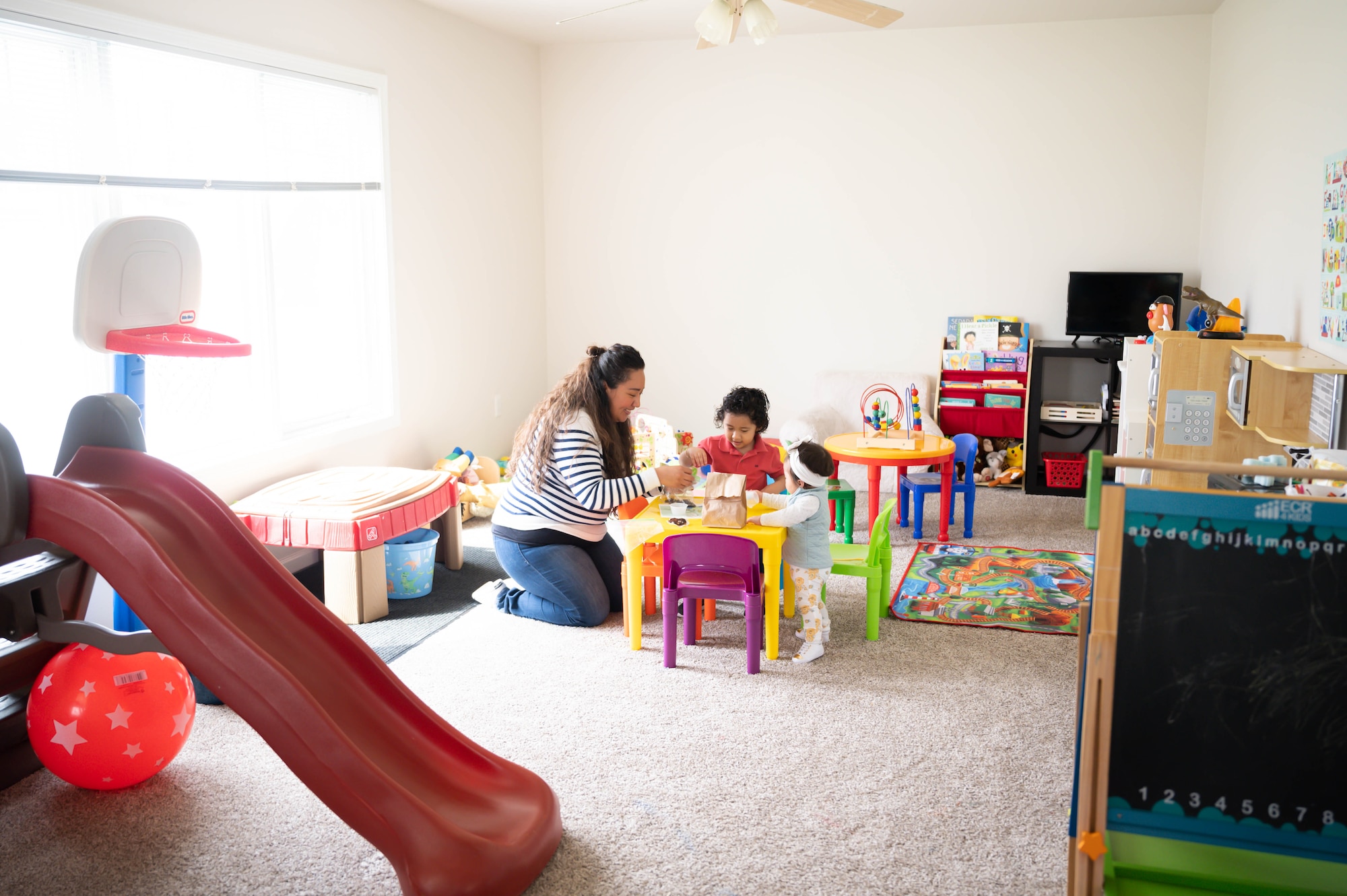 Woman and children sit around a table.