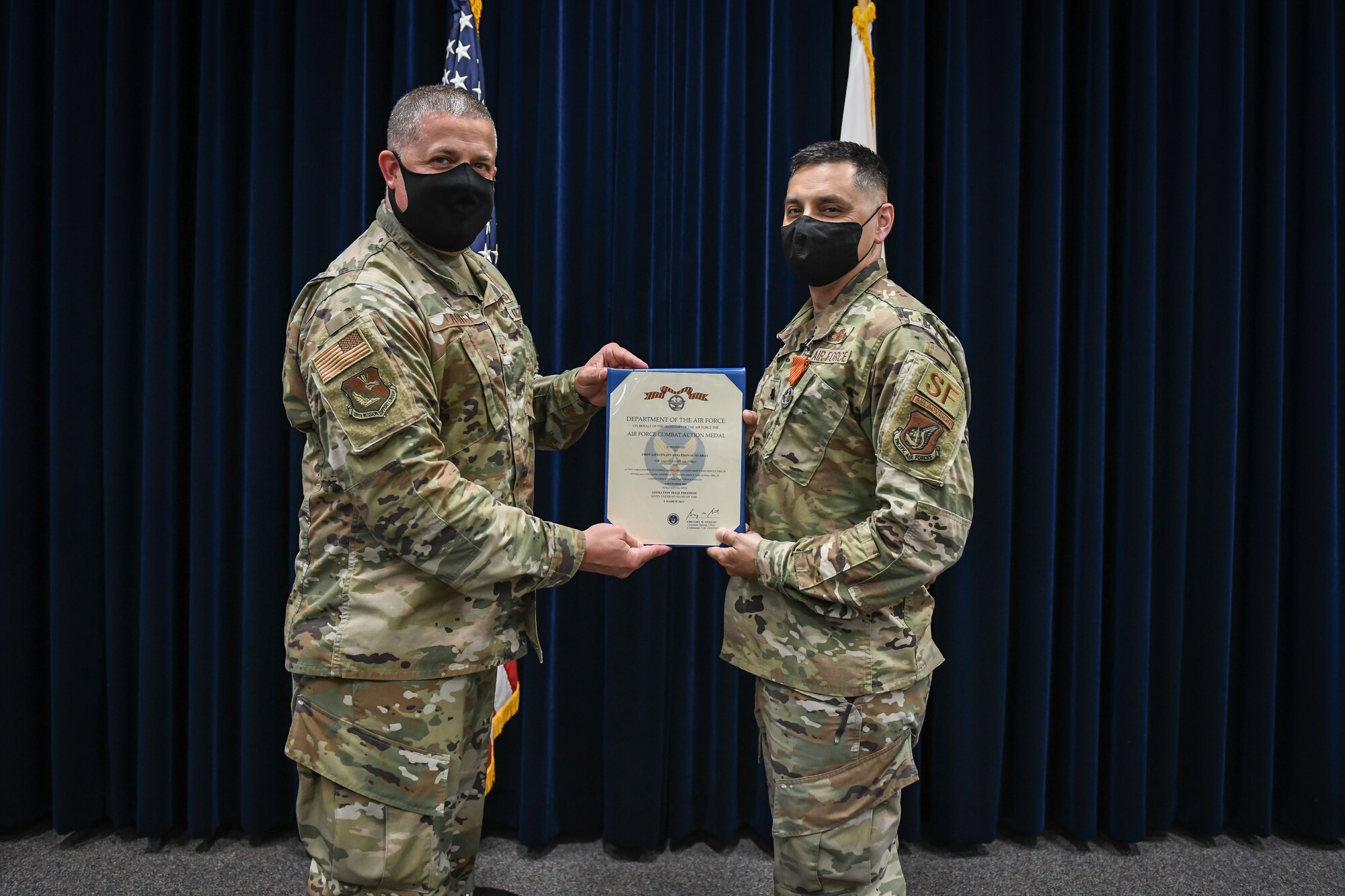 A man hands another man an award.