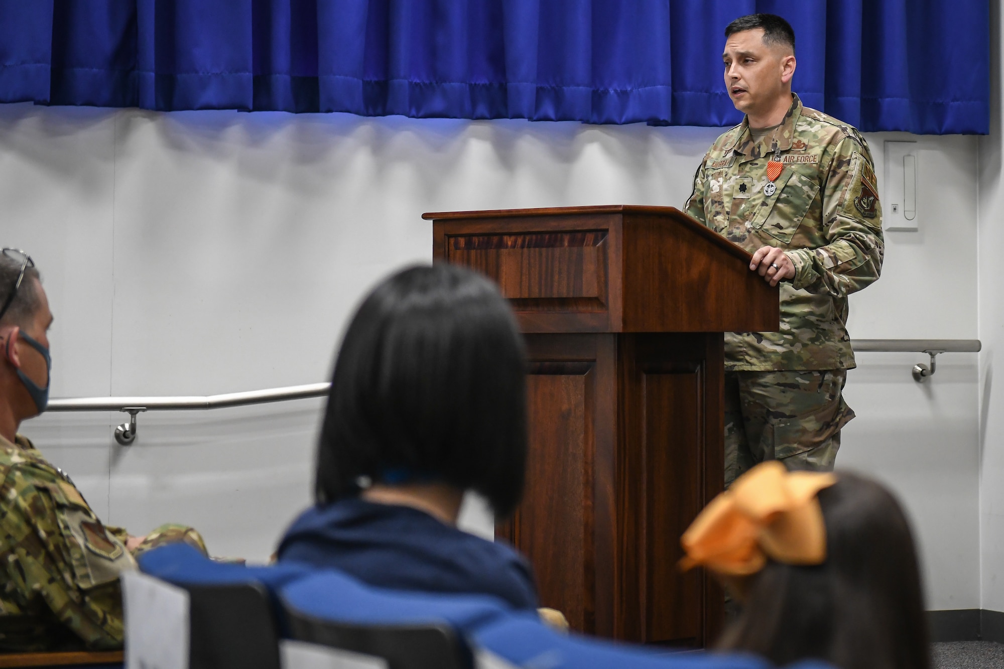 A man speaks in front of a crowd
