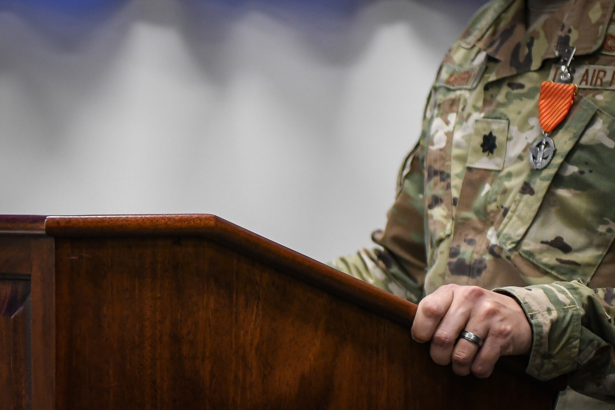 A man grips a podium tightly while speaking