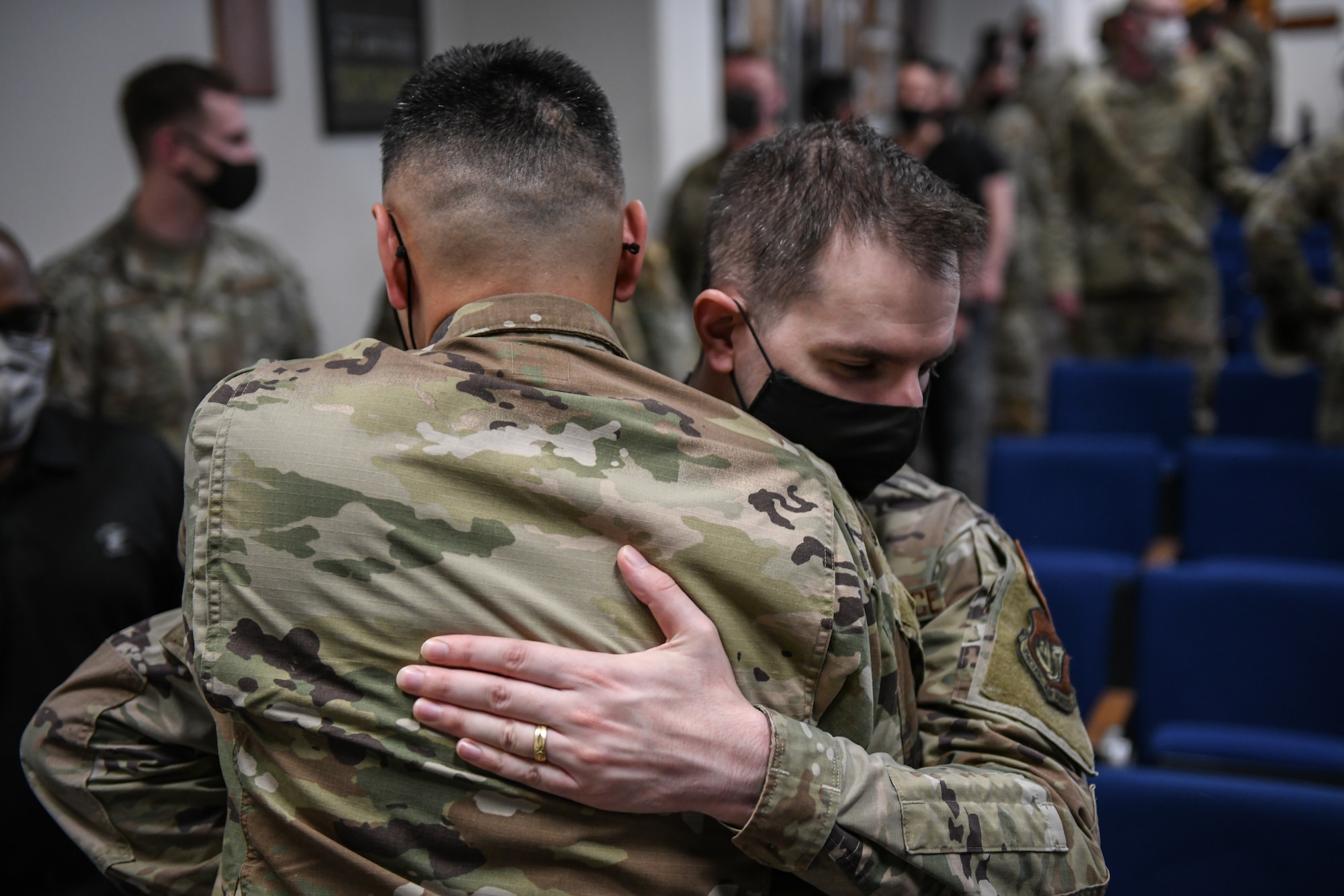 Two men hug.