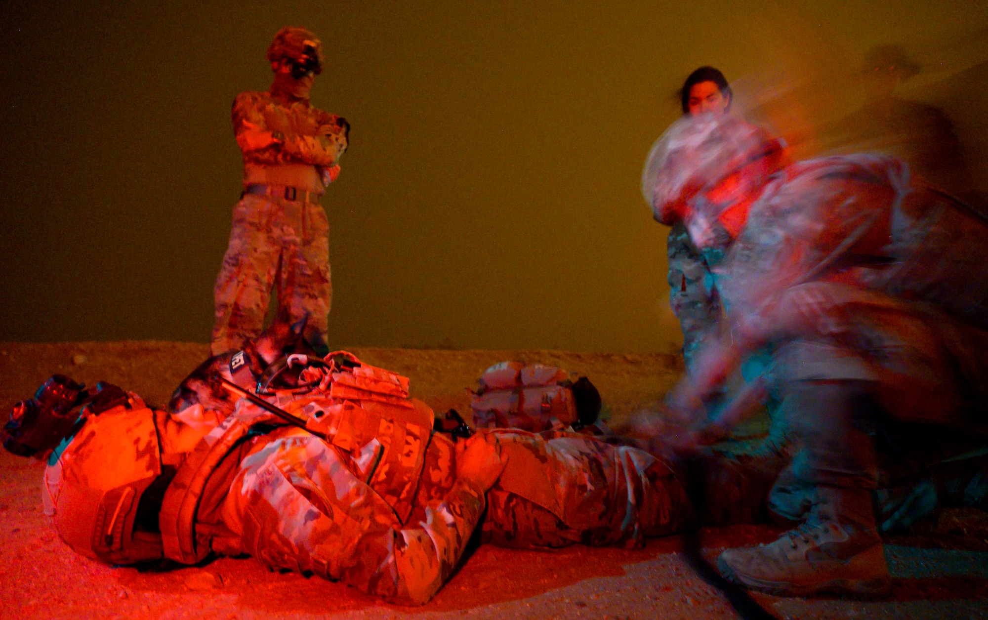 U.S. Air Force Staff Sgt. Maria Delgadillo, a military working dog handler with the 378th Expeditionary Security Forces Squadron, and her MWD, Rony, receive simulated medical care during a quick response training event in blackout conditions at Prince Sultan Air Base, Kingdom of Saudi Arabia, June 12, 2021. PSAB Explosive Ordnance Disposal, Security Forces and Medical personnel participated in integrated training to bolster defensive capabilities and maintain readiness at all times. (U.S. Air Force photo by Senior Airmen Samuel Earick)