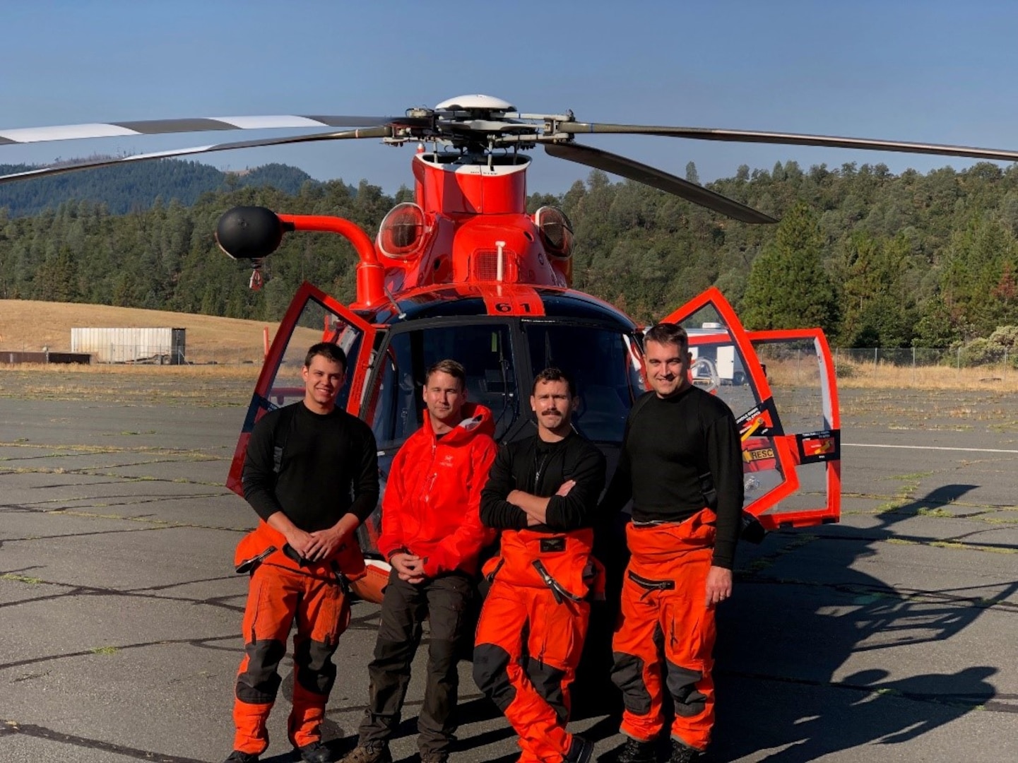 The crew of Coast Guard rescue helicopter from U.S. Coast Guard Sector Humboldt Bay following a daring night rescue of two firefighters who were seriously injured while battling the Middle Fire on the Shasta-Trinity National Forest in 2019. From left to right: Petty Officer 2nd Class Tyler Cook, flight mechanic; Petty Officer 1st Class Graham McGinnis, rescue swimmer; Lt. Adam Ownbey, co-pilot; Lt. Cmdr. Derek Schramel, aircraft commander. (U.S. Coast Guard photo)
