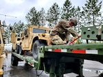 A Washington National Guard member of the 1041st Transportation Company ensures equipment is tied down before departing Fairchild Air Force Base, Wash., June 7, 2021, for annual training at Fort Harrison, Montana.