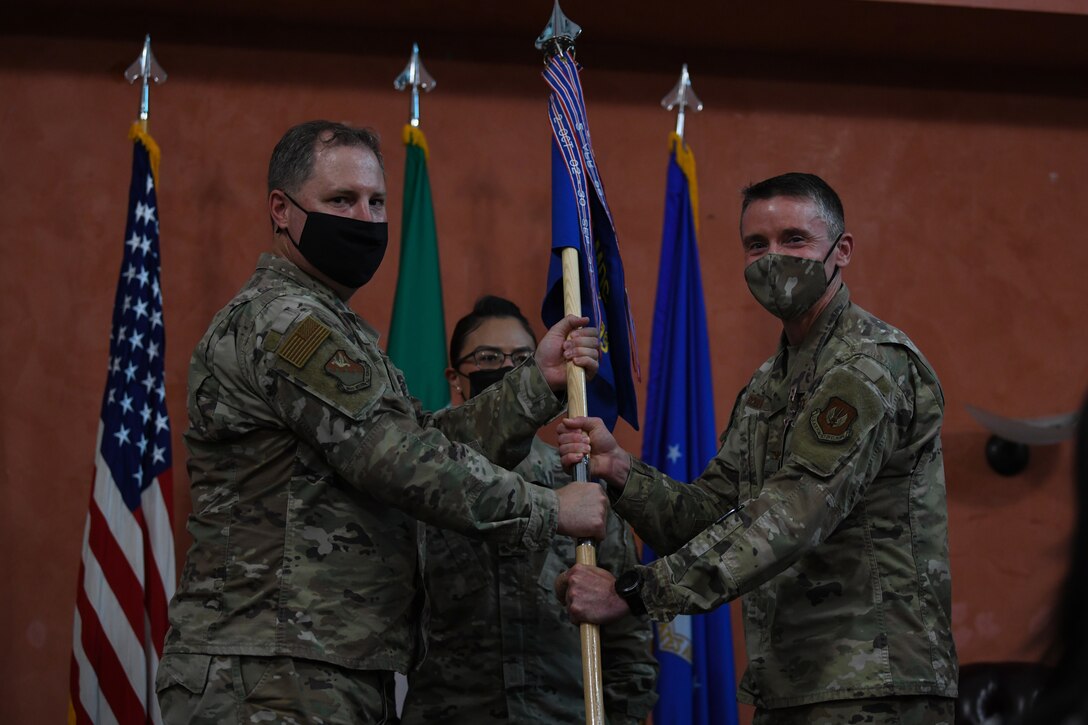 U.S. Air Force Col. Mark Roberts, 31st Dental Squadron (DS) outgoing commander, right, passes the guidon to U.S. Air Force Col. Wade Adair, 31st Medical Group commander, during a change of command at Aviano Air Base, Italy, June 22, 2021. The 31st DS provides approximately 22,000 patient visits annually to almost 8,700 beneficiaries. (U.S. Air Force photo by Airman First Class Taryn Onyon)