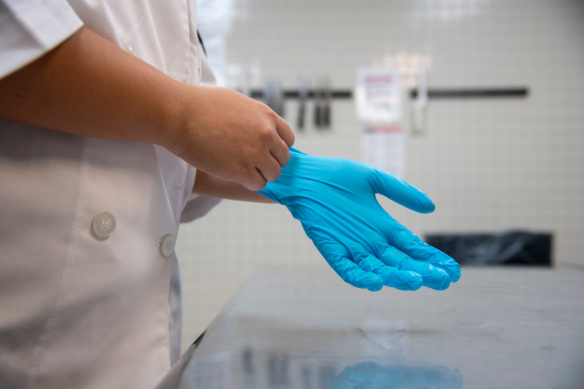 U.S. Air Force Senior Airman Haley Garces, 6th Force Support Squadron food services journeyman, dons a pair of gloves at MacDill Air Force Base, Florida, June 15, 2021.