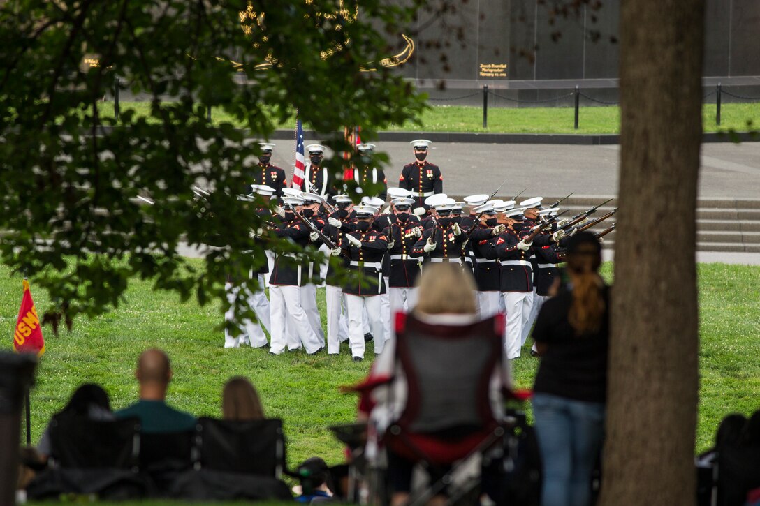 Marines with the Silent Drill Platoon execute their “bursting bomb” sequence during a Tuesday Sunset Parade at the Marine Corps War Memorial, Arlington, VA, June 23, 2021. Major Gen. Julian D. Alford, commanding general, Training Command, was the hosting official and Dr. Salim Lala, assistant professor of surgery, Division of Vascular Surgery – Department of Surgery, the GW Medical Facility Associates, Washington D.C., was the guest of honor. (U.S. Marine Corps photo by Lance Cpl. Tanner Lambert)