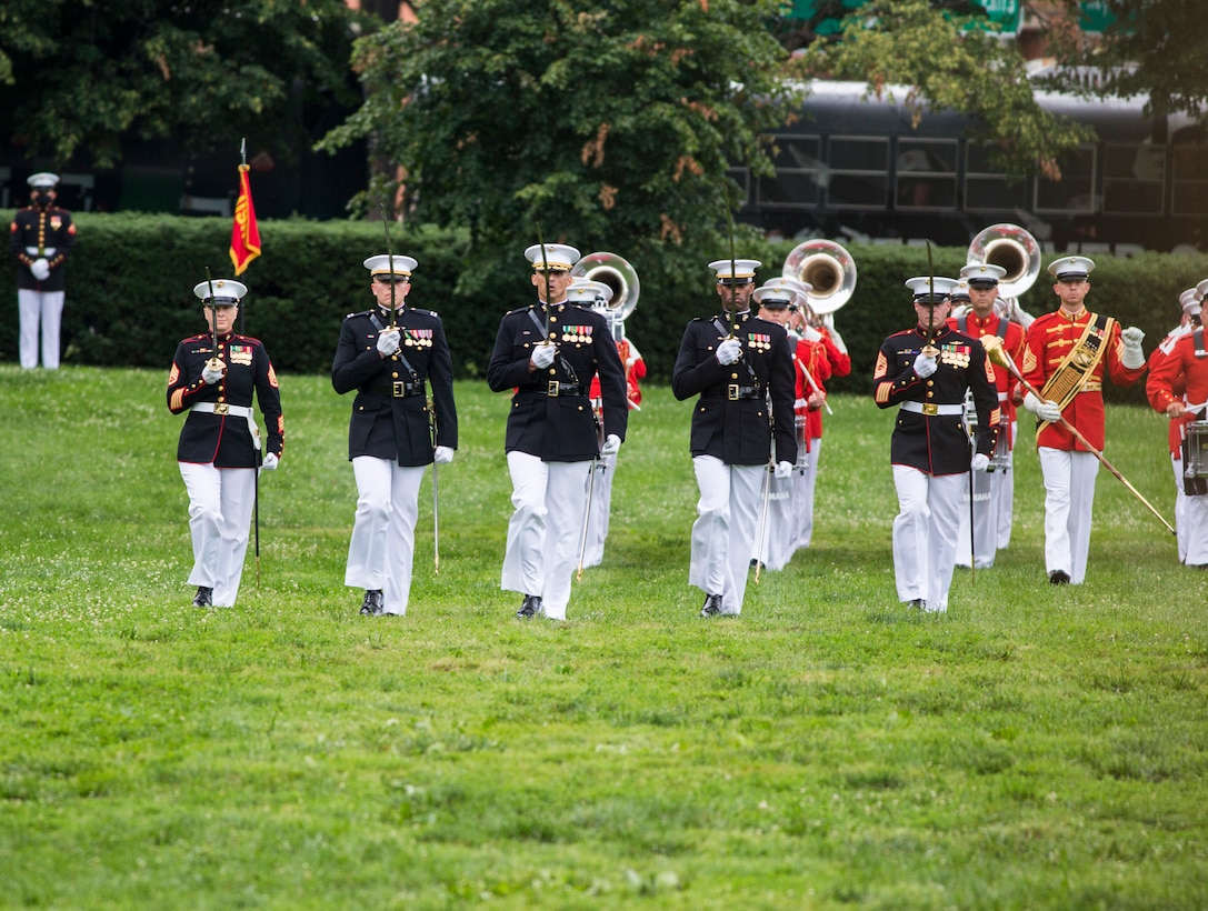 Marines with the Marine Barracks Washington parade staff execute “eyes right” during a Tuesday Sunset Parade at the Marine Corps War Memorial, Arlington, VA, June 23, 2021. Major Gen. Julian D. Alford, commanding general, Training Command, was the hosting official and Dr. Salim Lala, assistant professor of surgery, Division of Vascular Surgery – Department of Surgery, the GW Medical Facility Associates, Washington D.C., was the guest of honor. (U.S. Marine Corps photo by Lance Cpl. Tanner Lambert)
