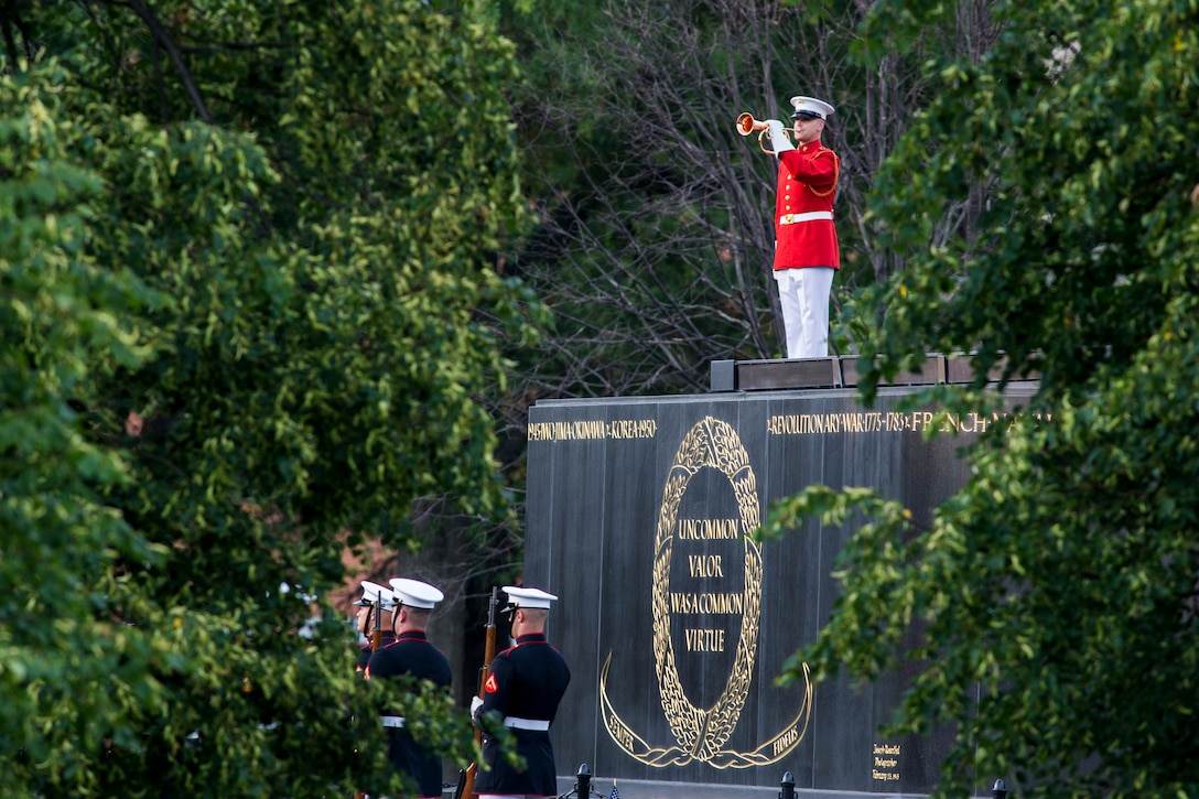 Staff Sgt. Christopher Walker, ceremonial bugler, “The Commandant’s Own” United States Marine Drum and Bugle Corps, plays “Taps” during a Tuesday Sunset Parade at the Marine Corps War Memorial, Arlington, VA, June 23, 2021. Major Gen. Julian D. Alford, commanding general, Training Command, was the hosting official and Dr. Salim Lala, assistant professor of surgery, Division of Vascular Surgery – Department of Surgery, the GW Medical Facility Associates, Washington D.C., was the guest of honor. (U.S. Marine Corps photo by Lance Cpl. Tanner Lambert)