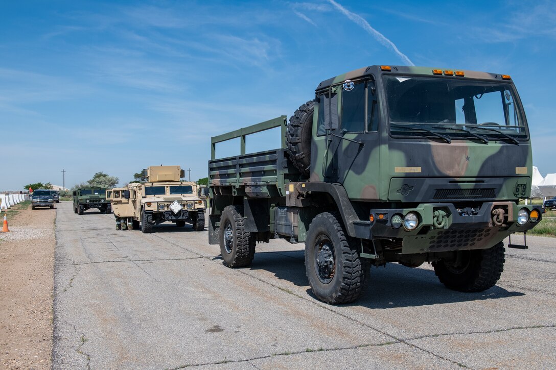 Military trucks lined up in a single line.