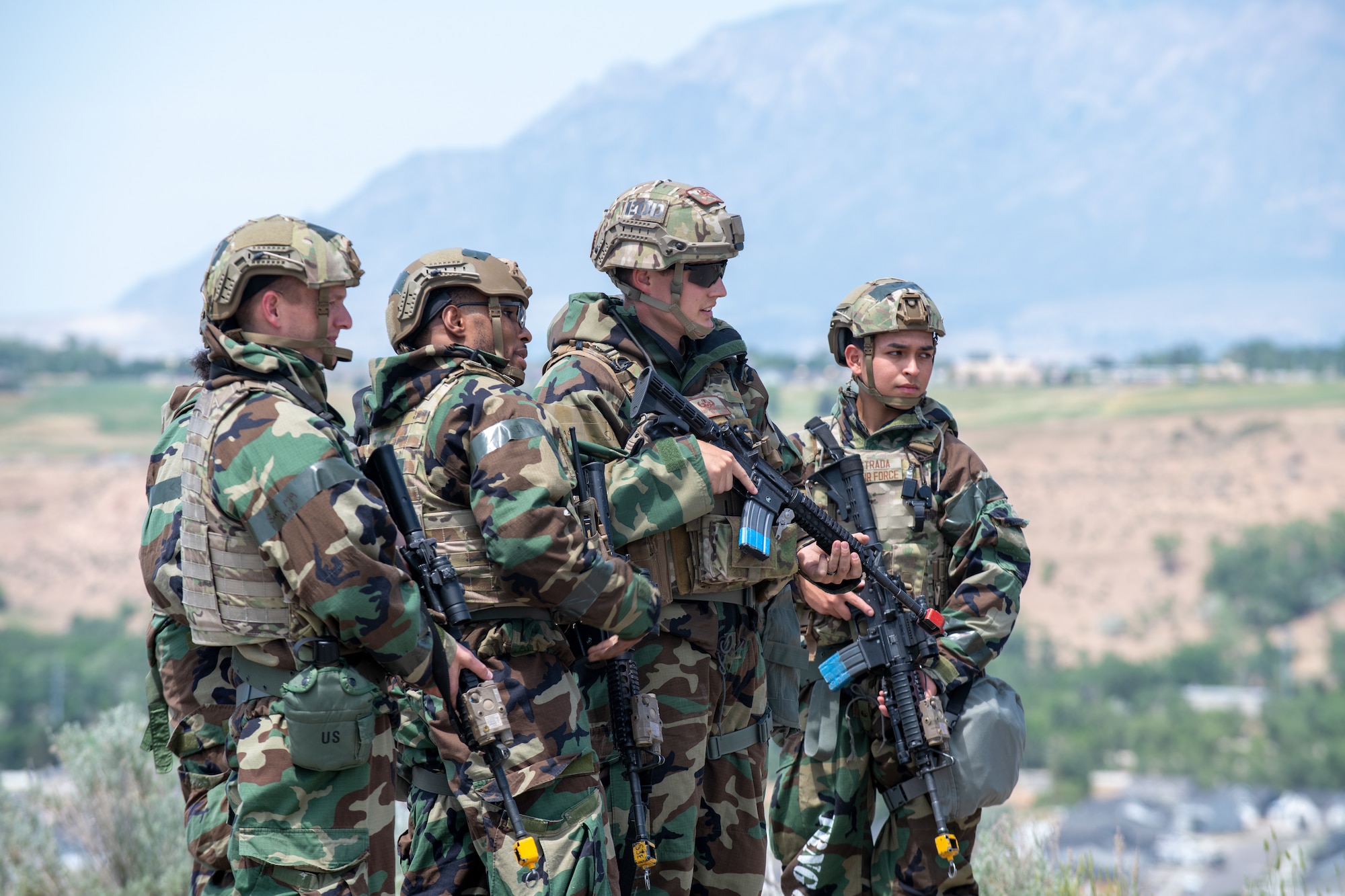 Four Airmen standing together bearing rifles.