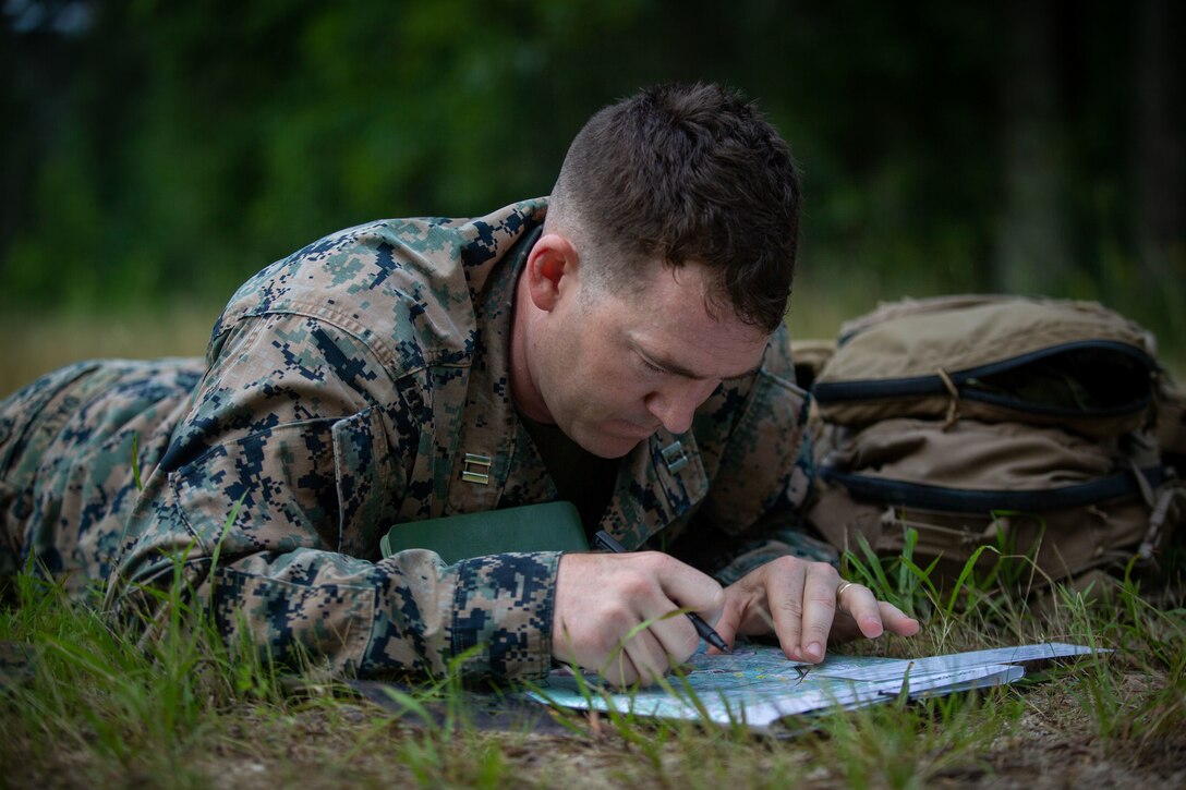 U.S. Marine Corps Capt. Kyle Daly, an infantry officer with 2d Marine Division (MARDIV), marks coordinates during a land navigation course as part of the Division Leader Assessment Program (DLAP) at Fort Pickett, Va., June 21, 2021. DLAP assesses the preparedness of 2d MARDIV's newly-assigned infantry Captains by evaluating their mental, moral, and physical readiness for infantry company command, ensuring the Division places the right leaders in front of the right companies at the right time. DLAP is a key component in the Division's mission to train and certify units that demonstrate apex levels of lethality, endurance and comprehensive warfighting ability to be employed by their gaining higher headquarters immediately upon deployment. (U.S. Marine Corps photo by Lance Cpl. Brian Bolin Jr.)
