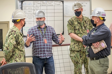 Rear Admiral Jeffrey Jablon, commander, Submarine Force, U.S. Pacific Fleet, is briefed on process improvements by Matt VanRavenhorst, NSS-SY champion, middle left, and Dan Arnell, Shop 31 production superintendent, right, June 8, 2021, during a tour of Puget Sound Naval Shipyard & Intermediate Maintenance Facility in Bremerton, Washington. (PSNS & IMF photo by Scott Hansen)