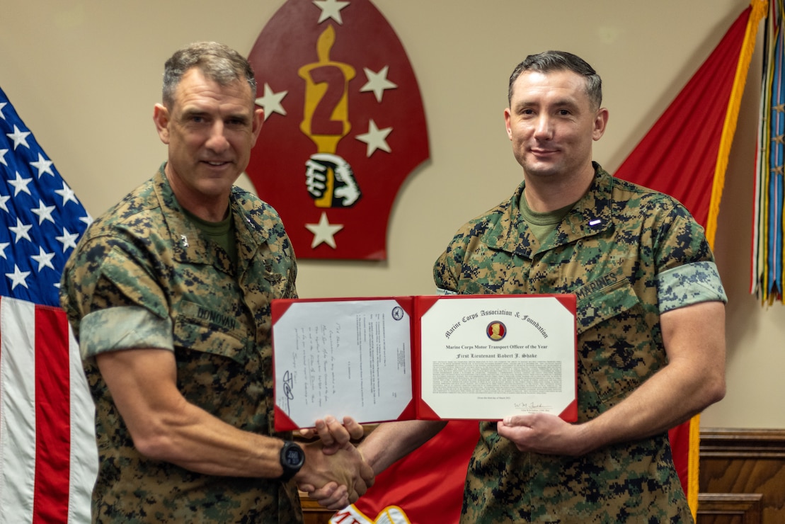 U.S. Marine Corps Maj. Gen. Frank Donovan, left, commanding general of 2d Marine Division (MARDIV), awards 1st Lt. Robert Shake, a motor transport officer with 1st Battalion, 6th Marine Regiment, 2d MARDIV with the Motor Transport Officer of the Year Award on Camp Lejeune, N.C., June 22, 2021. Shake, a native of Lodi, Calif., won the award for his outstanding achievements in growing his non-commissioned officers, maintaining a high-level of operational vehicles, and supporting the unit with exceptional motor transport capabilities. (U.S. Marine Corps photo by Lance Cpl. Jacqueline Parsons)