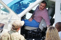 Student leans out of aircraft door while speaking to members.