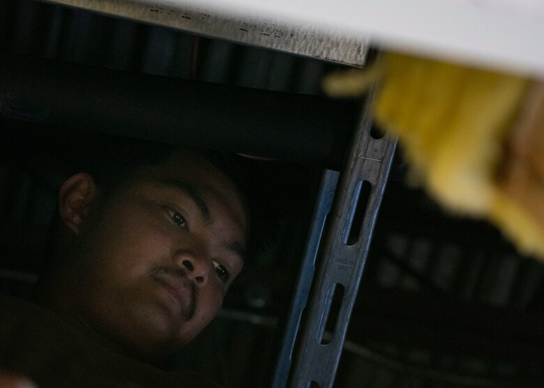 Senior Airman Joje Masaganda, 4th Civil Engineer Squadron heating, ventilation, air conditioning and refrigeration technician, stands inside a drop ceiling to access an indoor air conditioning unit at Seymour Johnson Air Force Base, North Carolina, June 14, 2021.