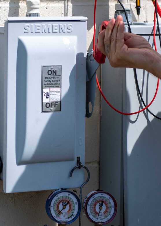 Senior Airman Joje Masaganda, left, and Staff Sgt. Mitchell Cole, 4th Civil Engineer Squadron heating, ventilation, air conditioning and refrigeration technicians, remove panels from an air conditioning package unit at Seymour Johnson Air Force Base, North Carolina, June 14, 2021.