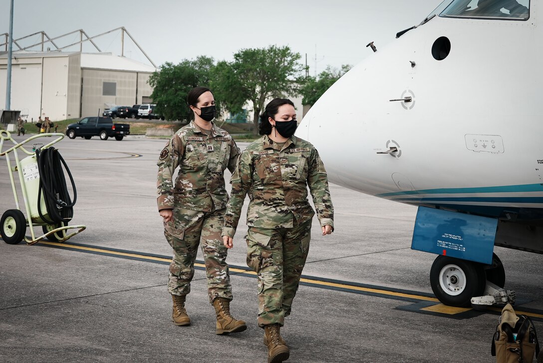 Two Airmen prepare to board a C-146A Wolfhound aircraft.