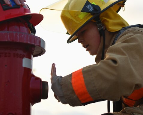 U.S. Marine Corps Lance Cpl. Alexis Telschow, Marine Corps Detachment student, demonstrates testing fire hydrant pressure during a training exercise on Goodfellow Air Force Base, Texas, June 11, 2021. Telschow applied core fire emergency service techniques she learned during the training exercise. (U.S. Air Force photo by Senior Airman Abbey Rieves)