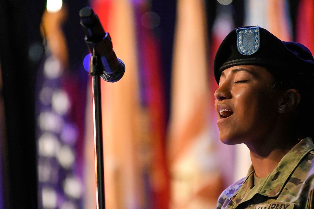 A soldier sings into a microphone.