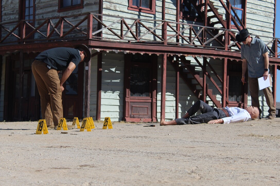 Office of Special Investigations Detachment 217 Special Agents Devon Henry, left, and Miles Jennings, examine the murder scene of town Marshal Fred White. They were part of a 23-person team participating in Crime Scene Training at the Mescal Movie set in Mescal, Ariz., where the 1993 Western, 'Tombstone' was shot. The unique venue provided period-correct clothing for the deceased, plus weapons and movie props to create the feel and atmosphere of the Old West. (Photo by William Hoffmann)