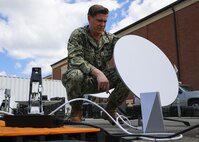 JOINT BASE LANGLEY-EUSTIS, Va. (June 23, 2021) Navy Information Systems Technician 1st Class Isaac Wilson, assigned to Joint Task Force Civil Support, configures a Starlink mobile satellite transceiver during Exercise Lightning Response on Fort Eustis, Virginia, June 23, 2021.