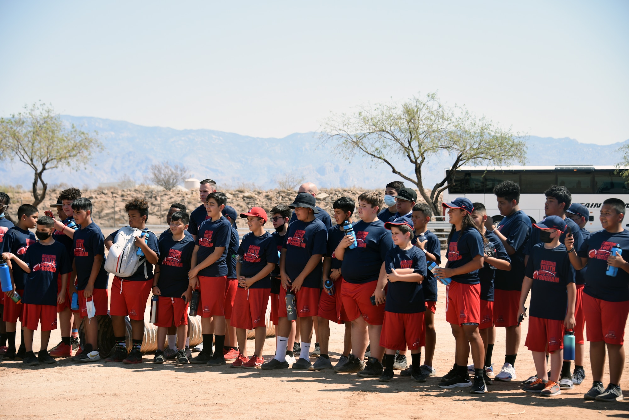 A photo of Children gathered around to watch a demonstration.