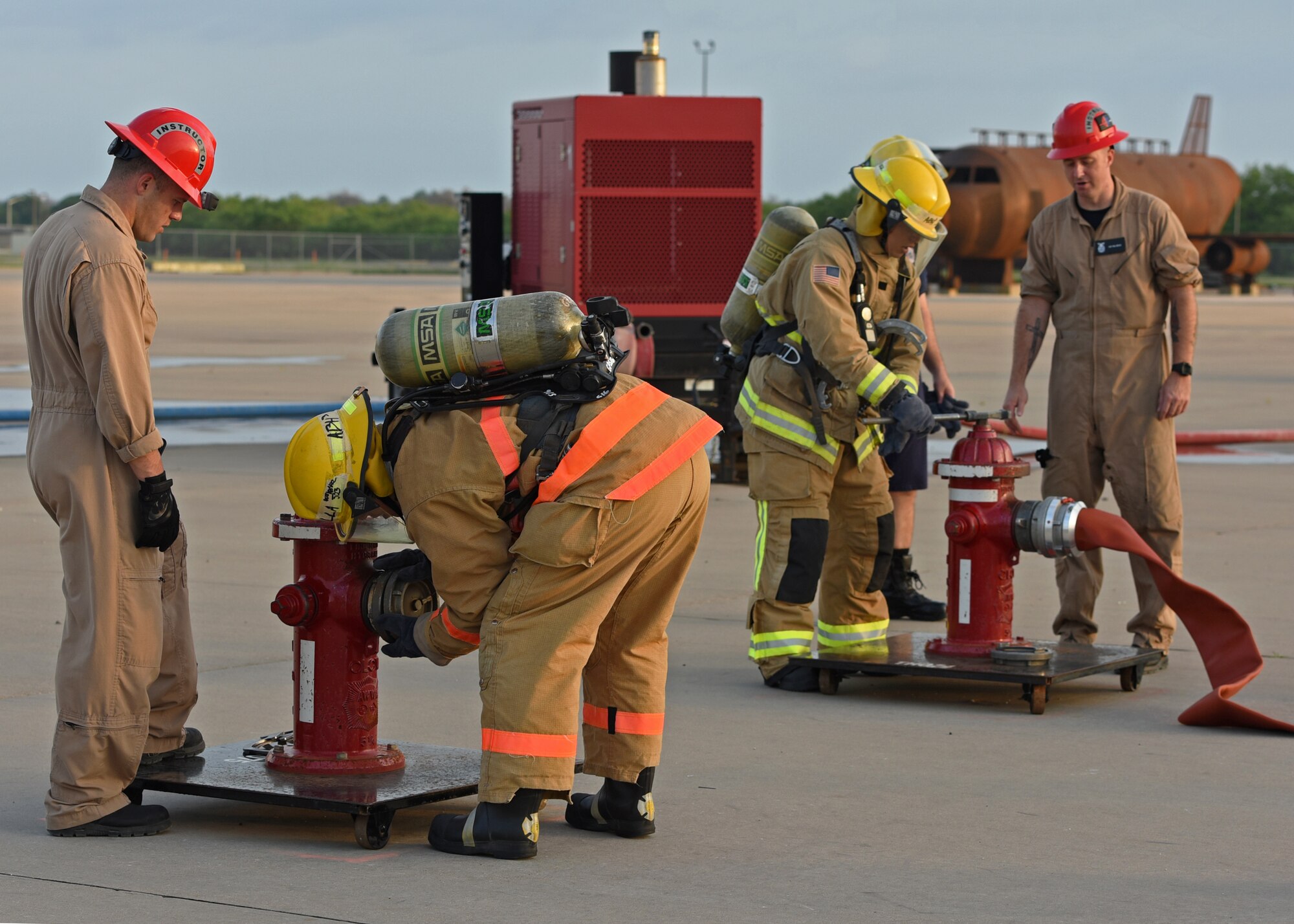 Joint service fire protection students from the 312th Training Squadron attach hoses to fire hydrants during their training on Goodfellow Air Force Base, Texas, June 11, 2021. Students were timed on how quickly they could carry the 200 foot fire hose and attach it to the fire hydrant. (U.S. Air Force photo by Senior Airman Abbey Rieves)