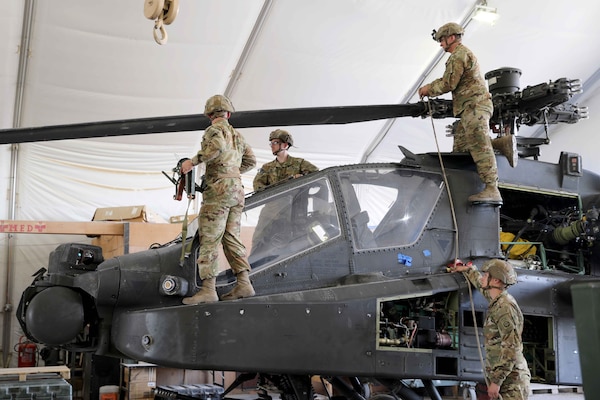 Soldiers work on a helicopter.