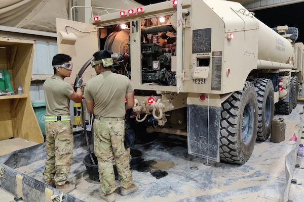 Soldiers work on a truck.
