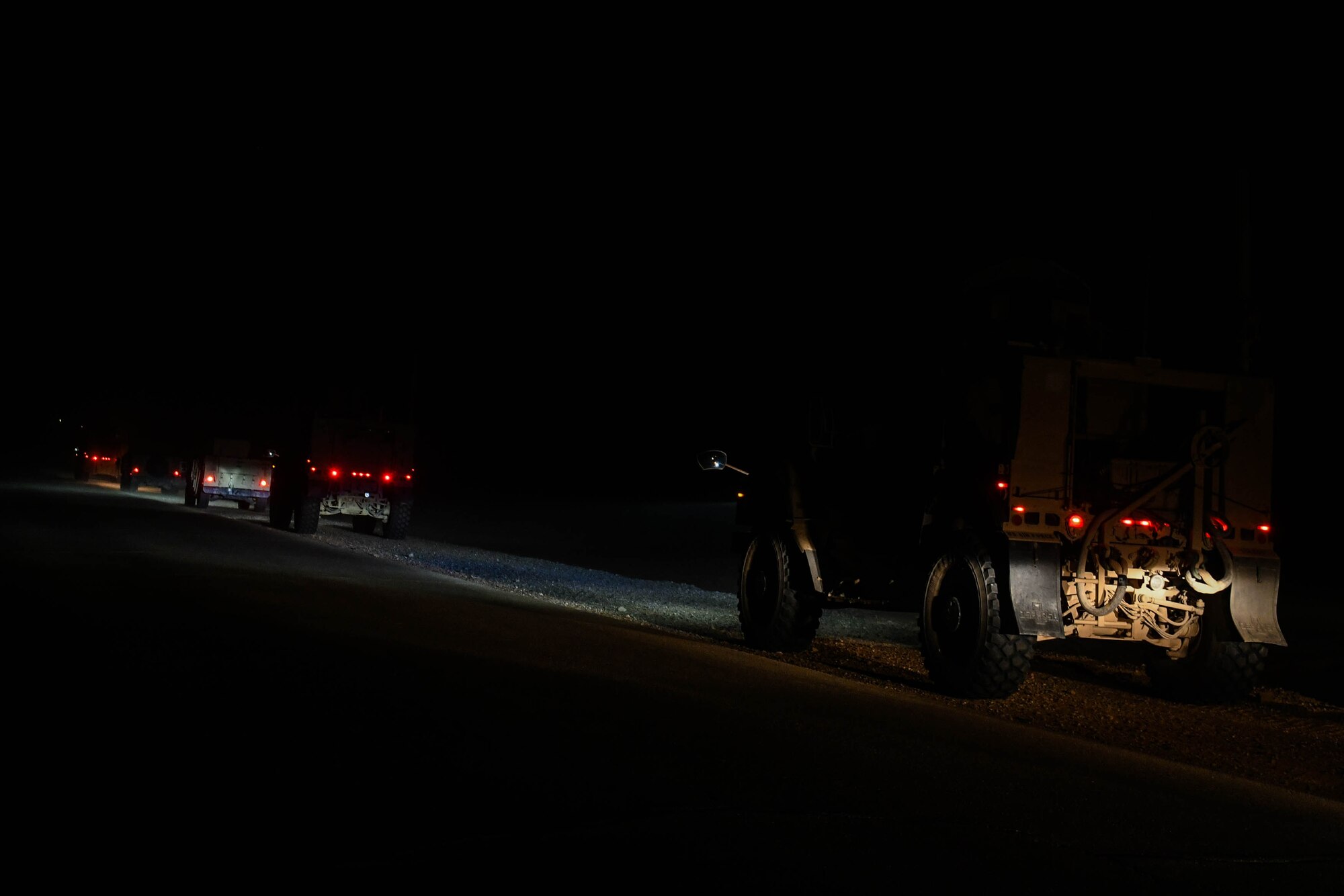 Several military vehicles, to include Mine Resistant Ambush Protected and High Mobility Multipurpose Wheeled vehicles, convoy to a remote location on Prince Sultan Air Base, Kingdom of Saudi Arabia, for a quick response training event in blackout conditions June 12, 2021. PSAB Explosive Ordnance Disposal, Security Forces and Medical personnel participated in integrated training to bolster defensive capabilities and maintain readiness at all times. (U.S. Air Force photo by Capt. Rachel Buitrago)