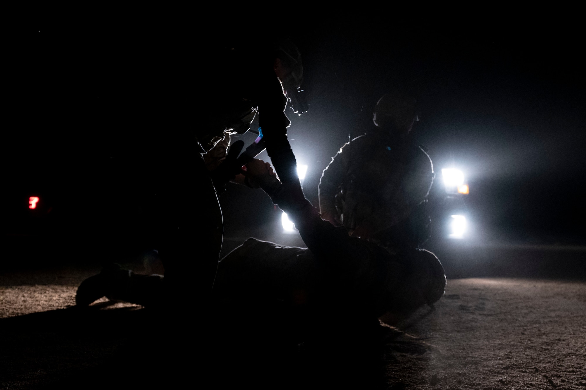 U.S. Air Force defenders with the 378th Expeditionary Security Forces Squadron subdue a simulated enemy participant in a quick response training event in blackout conditions at Prince Sultan Air Base, Kingdom of Saudi Arabia, June 12, 2021. PSAB Explosive Ordnance Disposal, Security Forces and Medical personnel participated in integrated training in order to bolster defensive capabilities and maintain readiness at all times. (U.S. Air Force photo by Staff Sgt. Caleb Pavao)