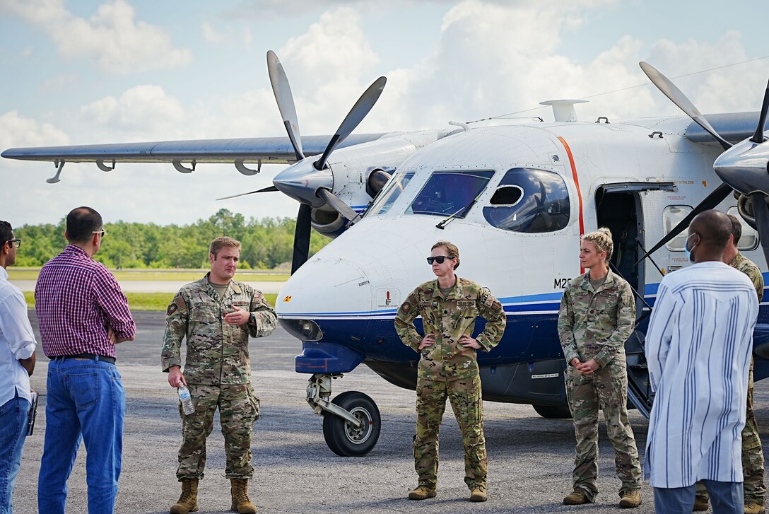 Airmen speak to students in front of aircraft