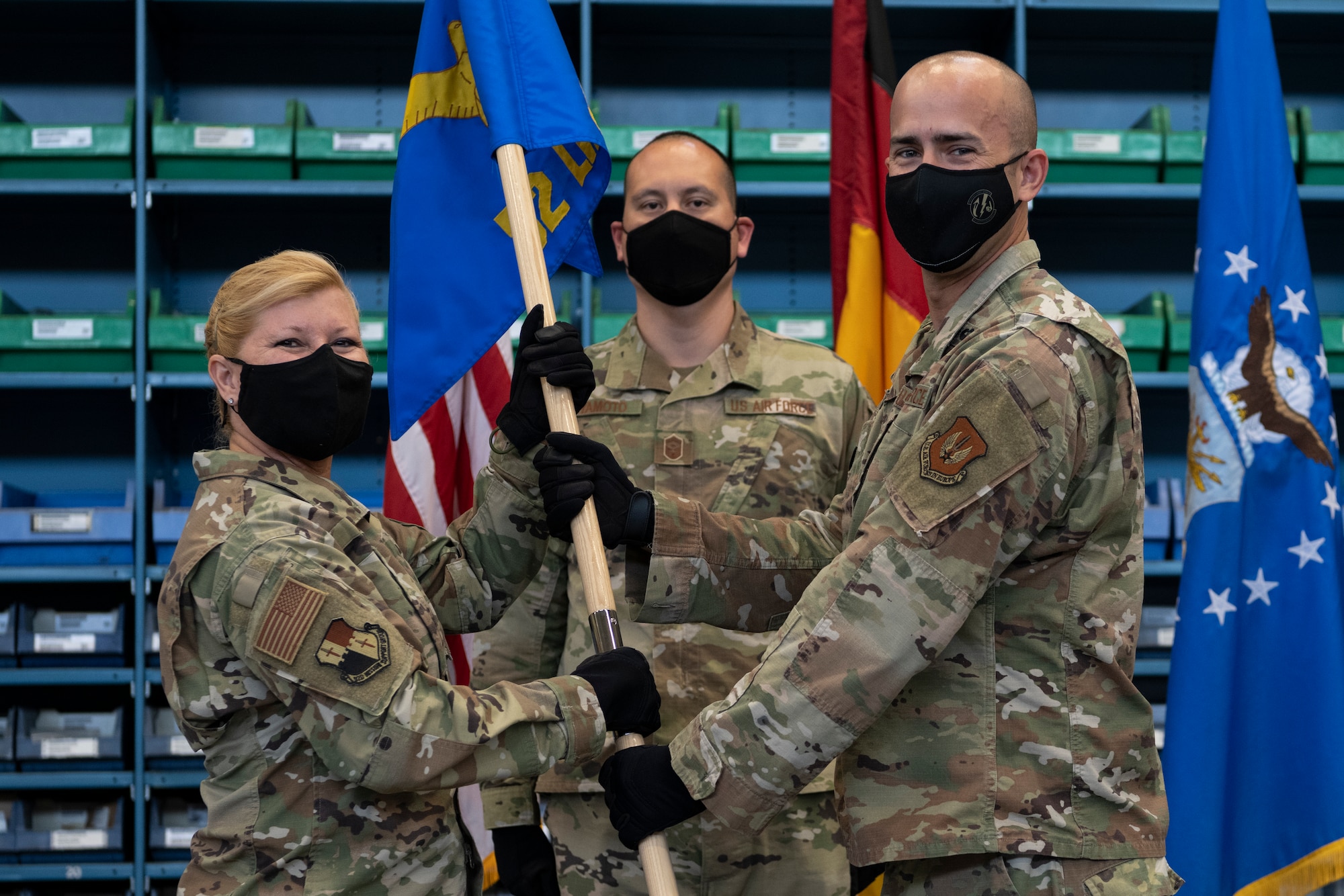 U.S. Air Force Lt. Col. Juan Fiol, former 52nd Logistics Readiness Squadron commander (right), passes the 52nd LRS guidon to U.S. Air Force Col. Betsy Ross, 52nd Mission Support Group commander, during the 52nd LRS change of command ceremony.