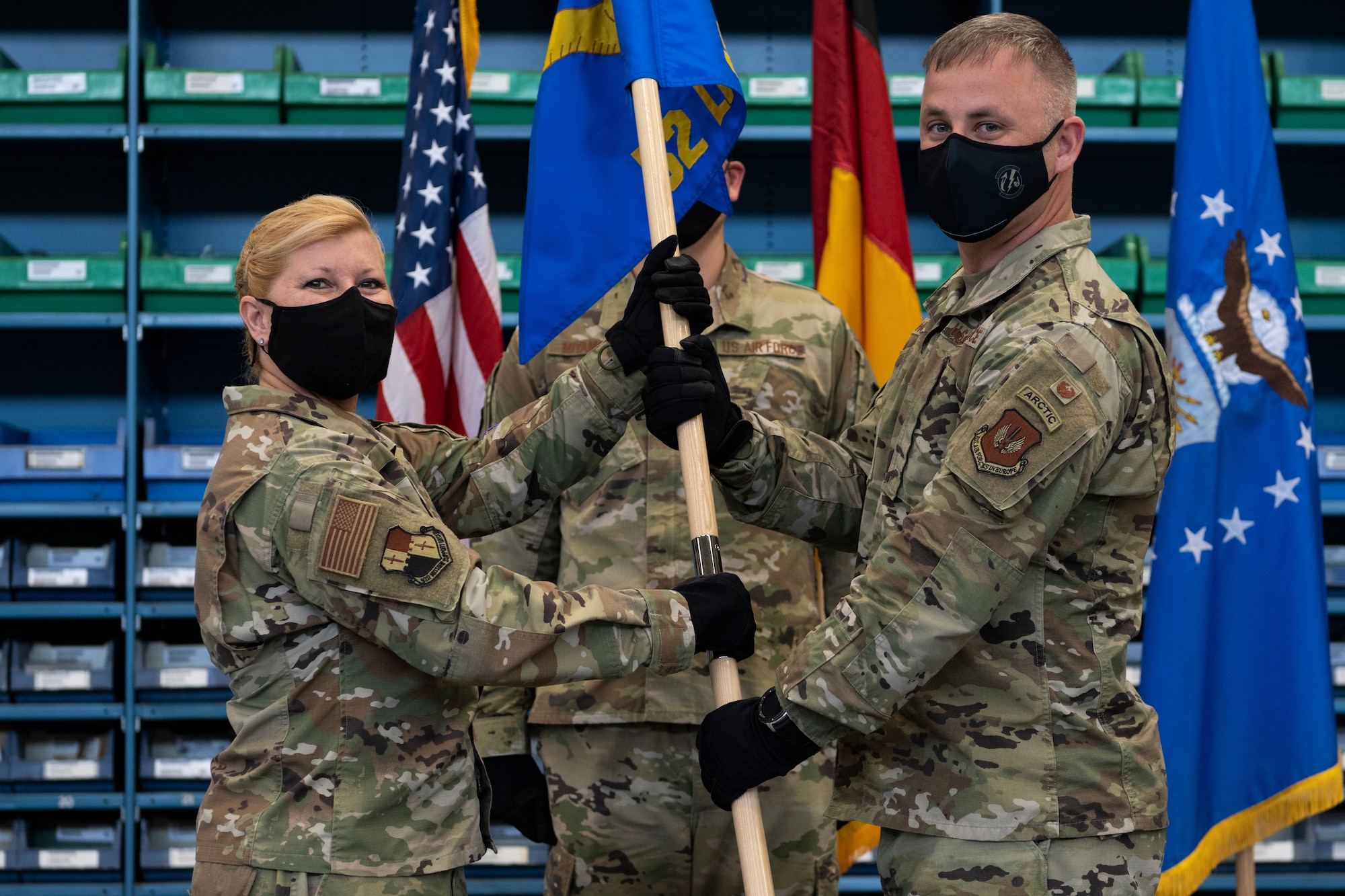 U.S. Air Force Col. Betsy Ross, 52nd Mission Support Group commander (left), passes the 52nd Logistics Readiness Squadron guidon to U.S. Air Force Maj. Donnie Horne, the 52nd LRS commander, during the 52nd LRS change of command ceremony.