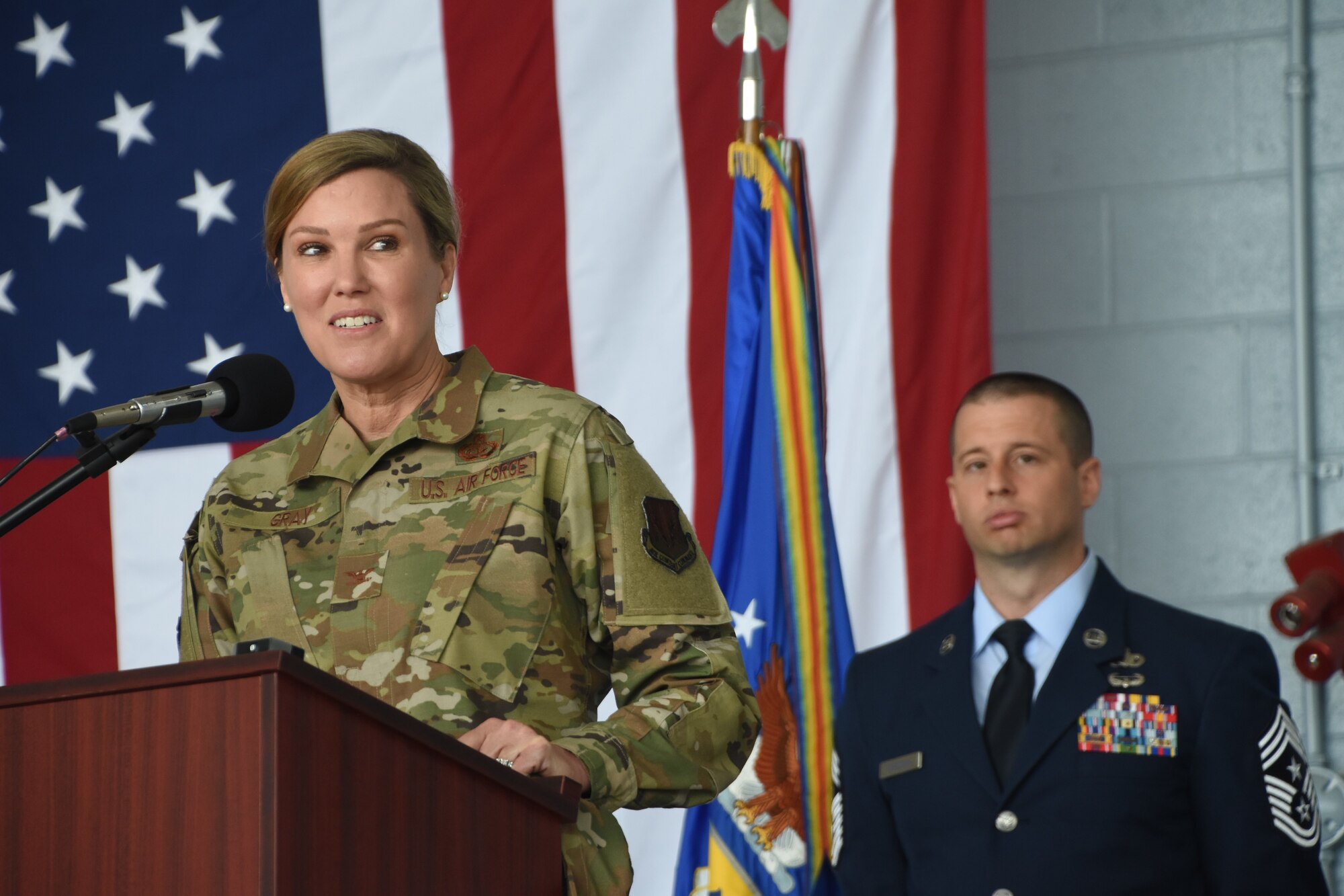 A woman in an air force uniform speaks at a podium.