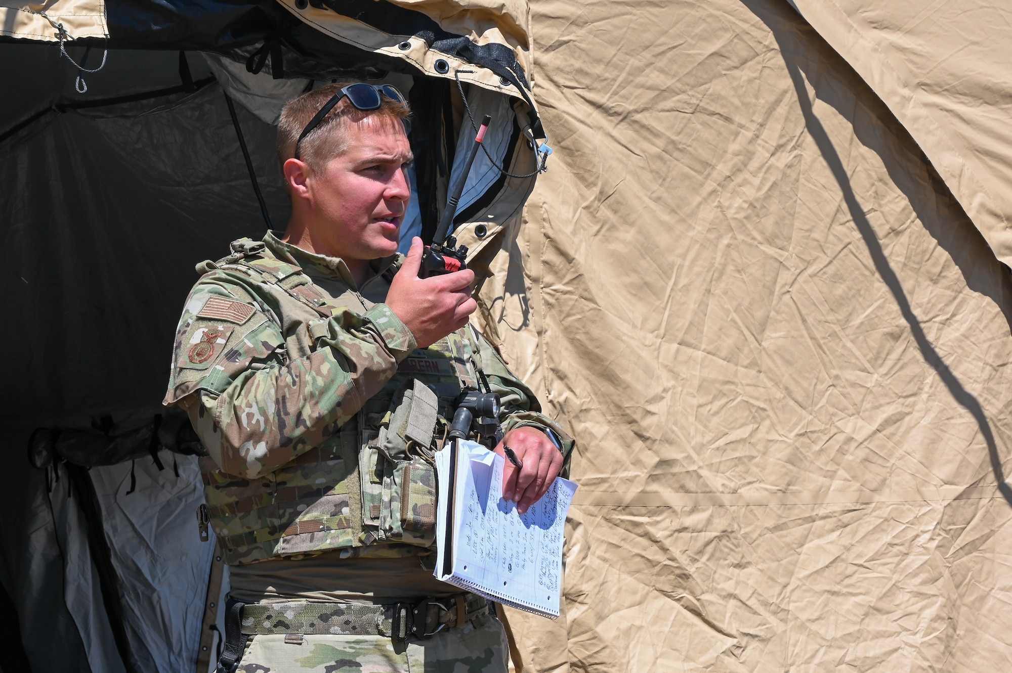 2nd Lt. Dan Dibbern, squad leader with the 155th Security Forces Squadron, completes a radio call in his zone during a simulated riot as a part of the Patriot 21 exercise at Fort McCoy, Wis., June 16, 2021. Patriot 21 is a training exercise for civilian emergency management and responders to work with military entities during natural disasters.