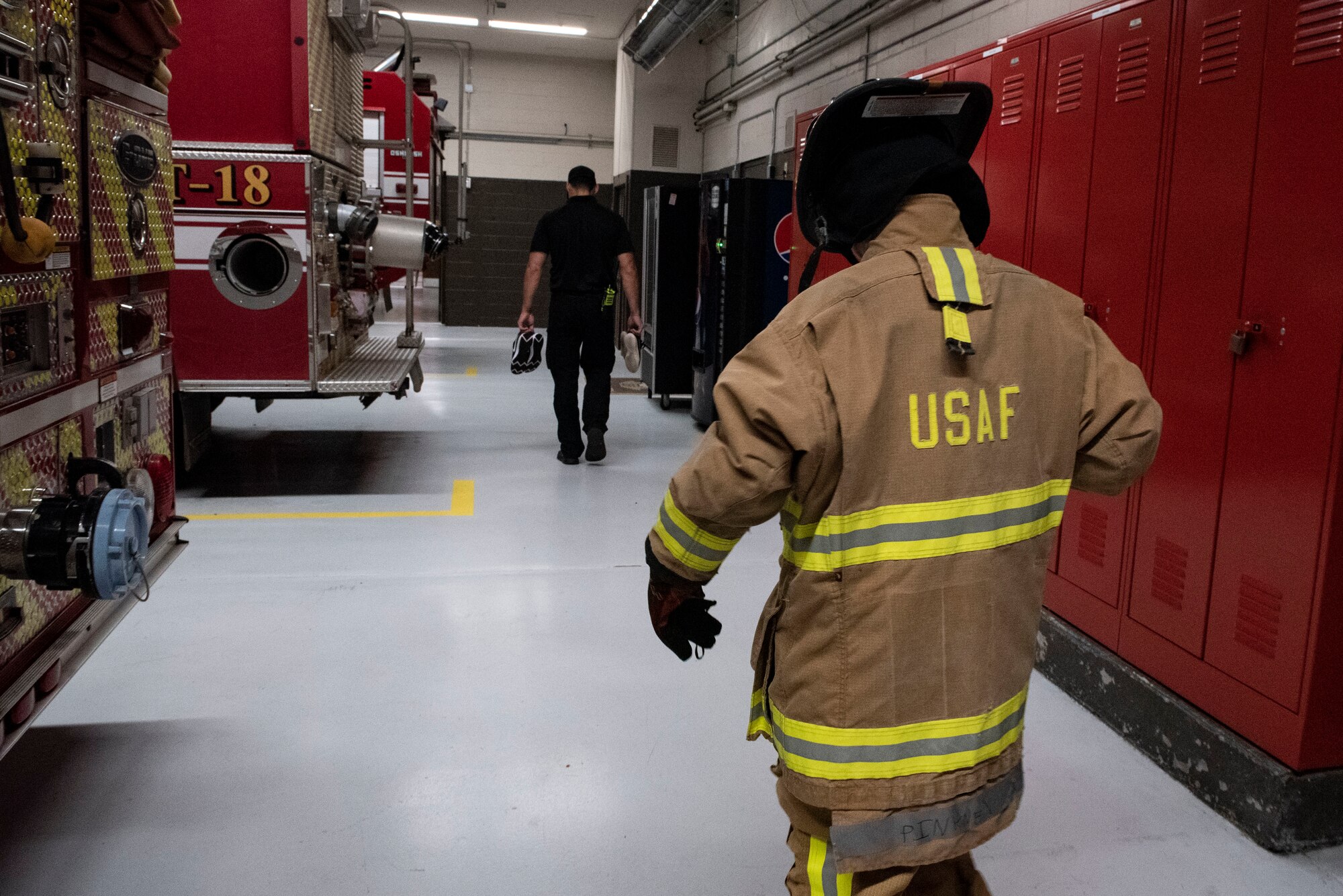 A photo of a teen walking in firefighter gear.