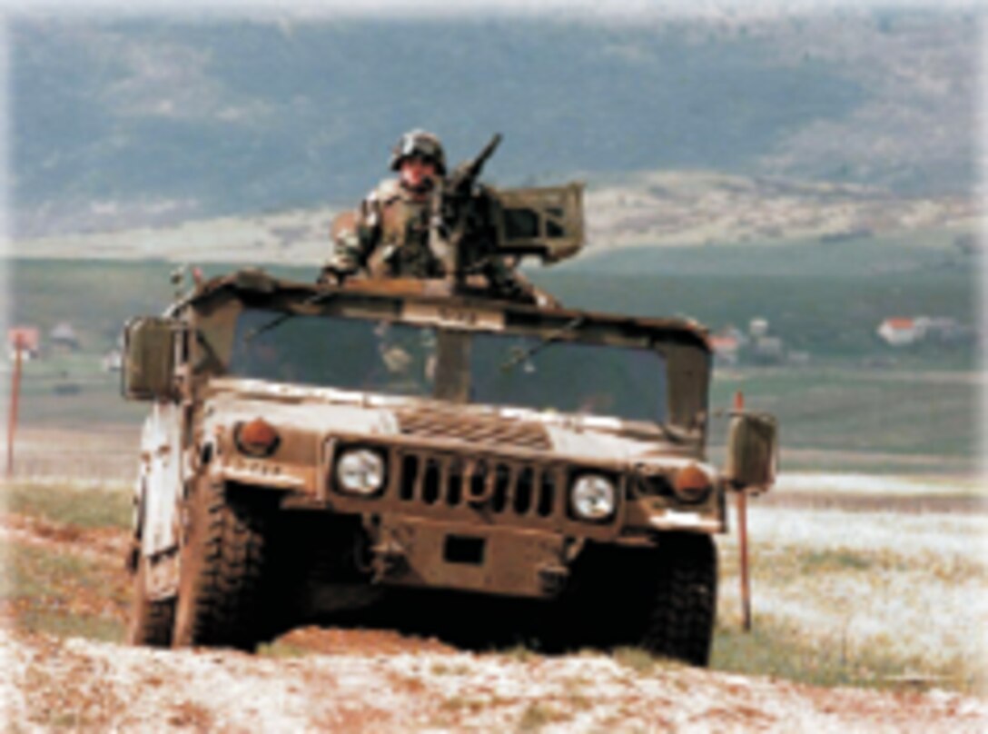 The HMMWV from the front angle, rolling across a rocky mountainous setting.