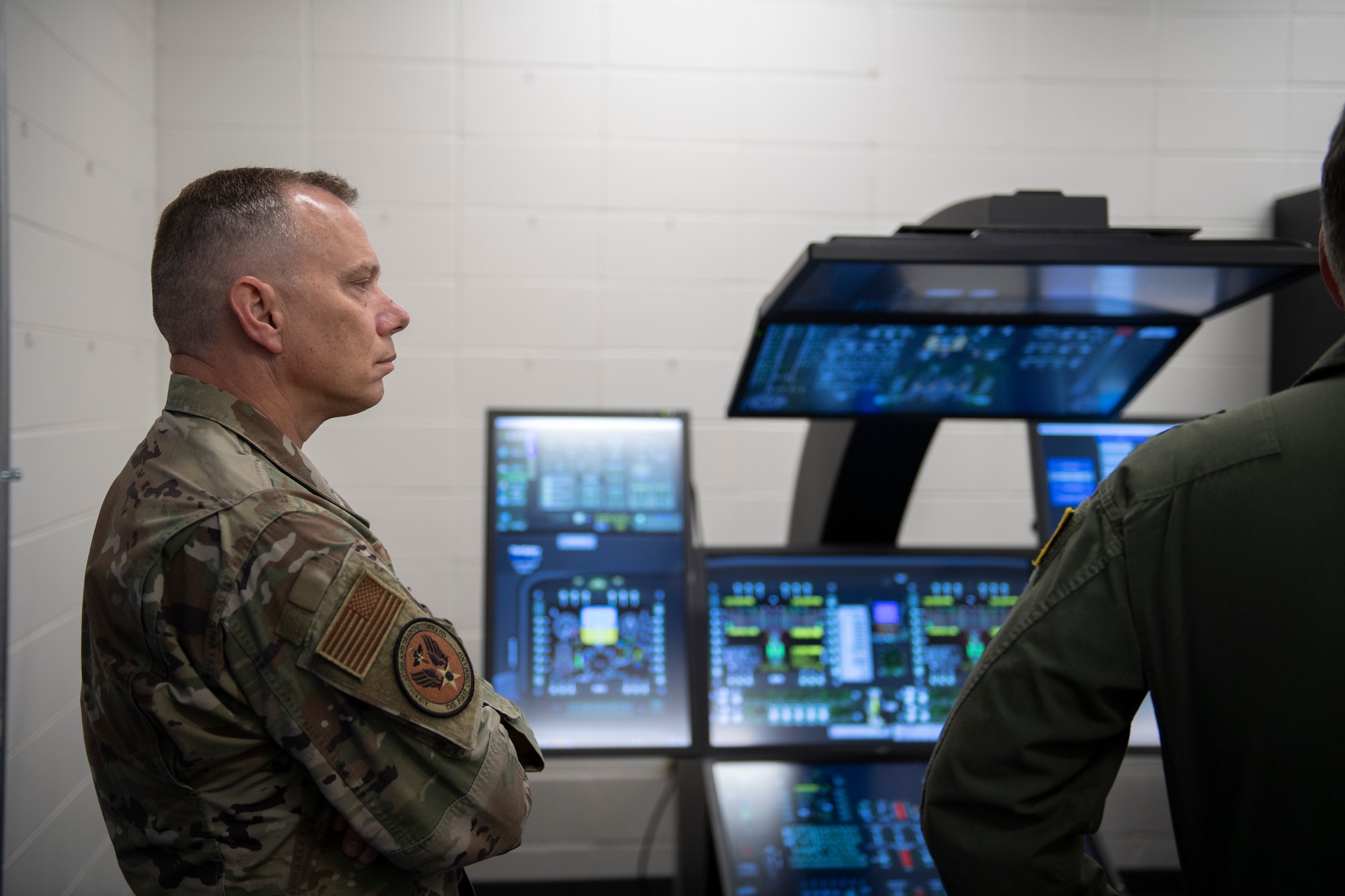 A photo of an Airman standing in front of computers.