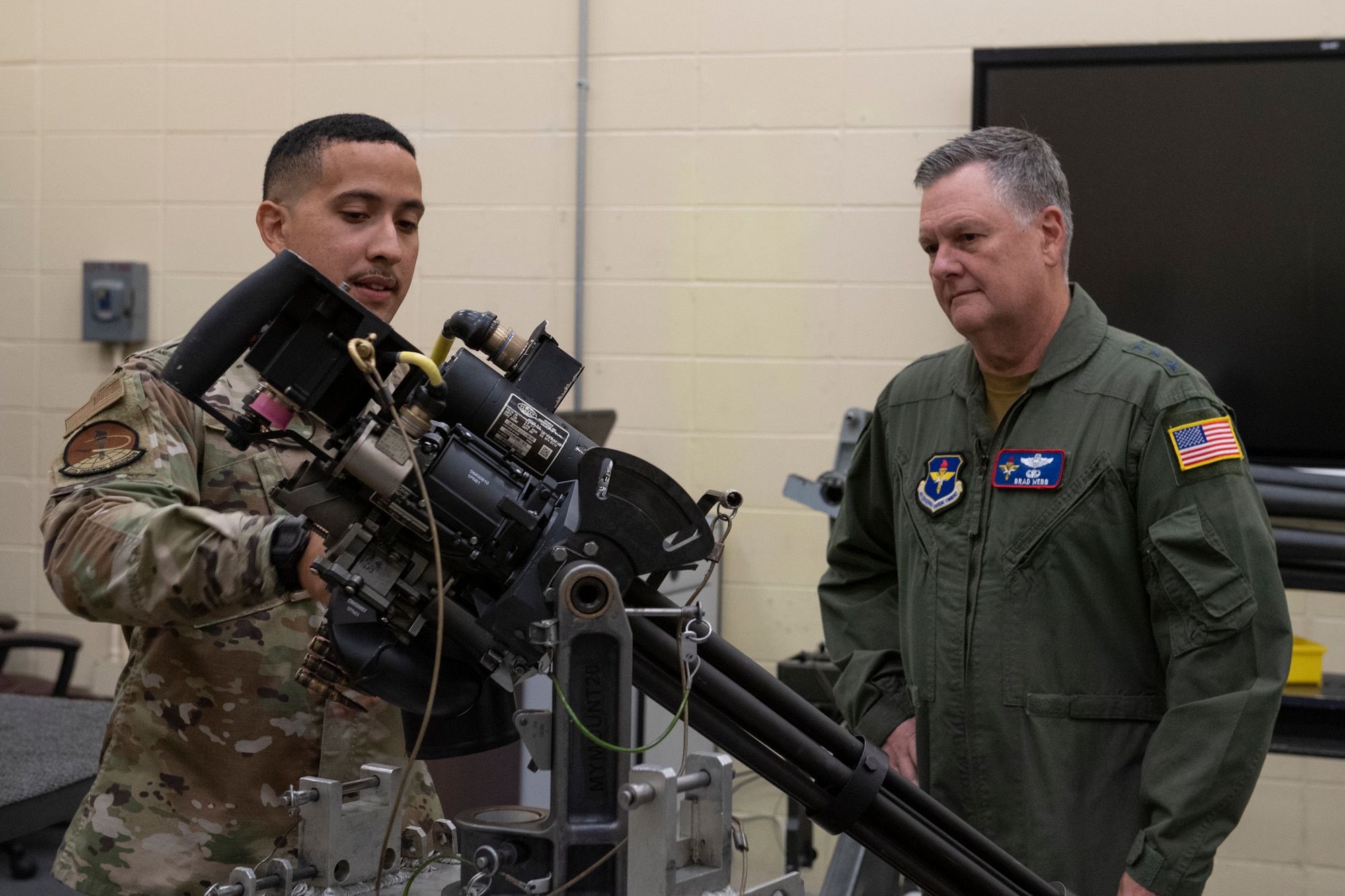 A photo of two people standing behind a gun system.
