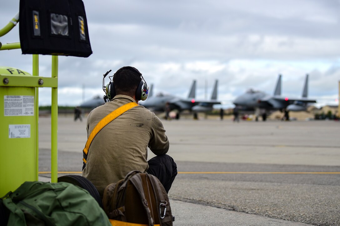Senior Airman Kodi Vigil, 80th Aircraft Maintenance Unit crew chief, watches Koku Jieitai (Japan Air Self-Defense Force) F-15J Eagles prepare for launch during Red Flag-Alaska 21-2 at Eielson Air Force Base, Alaska, June 18, 2021. RF-A is a Pacific Air Forces-directed field training exercise designed to provide U.S. and allied forces realistic air combat training for which enhances joint and bilateral interoperability in the Indo-Pacific region. (U.S. Air Force photo by Senior Airman Suzie Plotnikov)