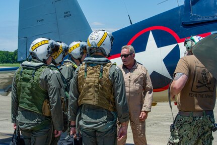 Mike Spalding, Chief Pilot Military Aviation Museum, speaks with naval aviators assigned to the “Jolly Rogers” of Strike Fighter Squadron (VFA) 103