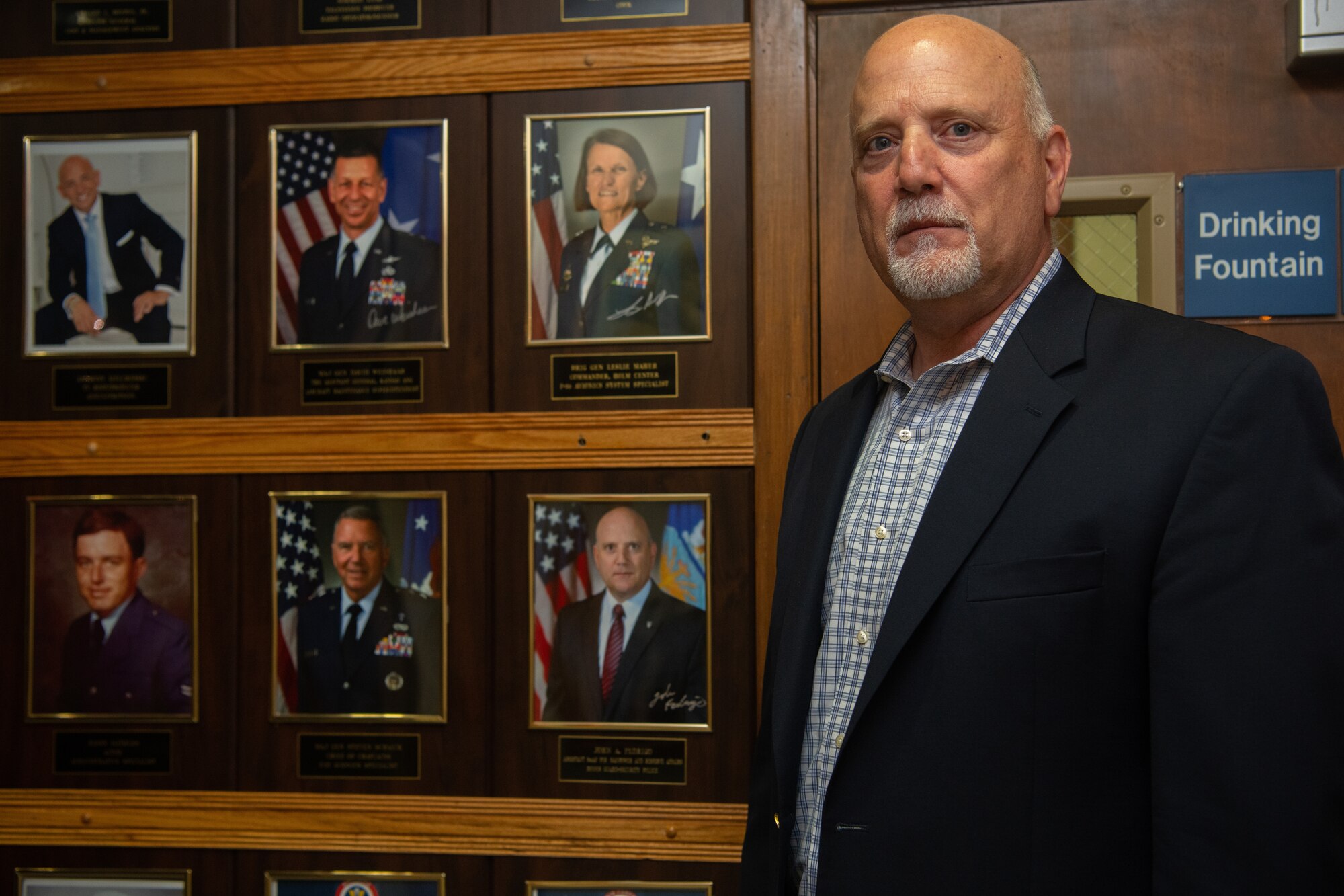 John Fedrigo, acting assistant secretary of the Air Force for Manpower and Reserve Affairs, poses for a photo beside his plaque on the Enlisted Heritage Hall Wall of Achievers after an induction ceremony on Maxwell-Gunter Annex, Alabama, June 21, 2021. The Wall of Achievers recognizes enlisted Airmen like Fedrigo, who served from 1981-2002, who attain fame or notoriety to include general officers, authors, actors and politicians.