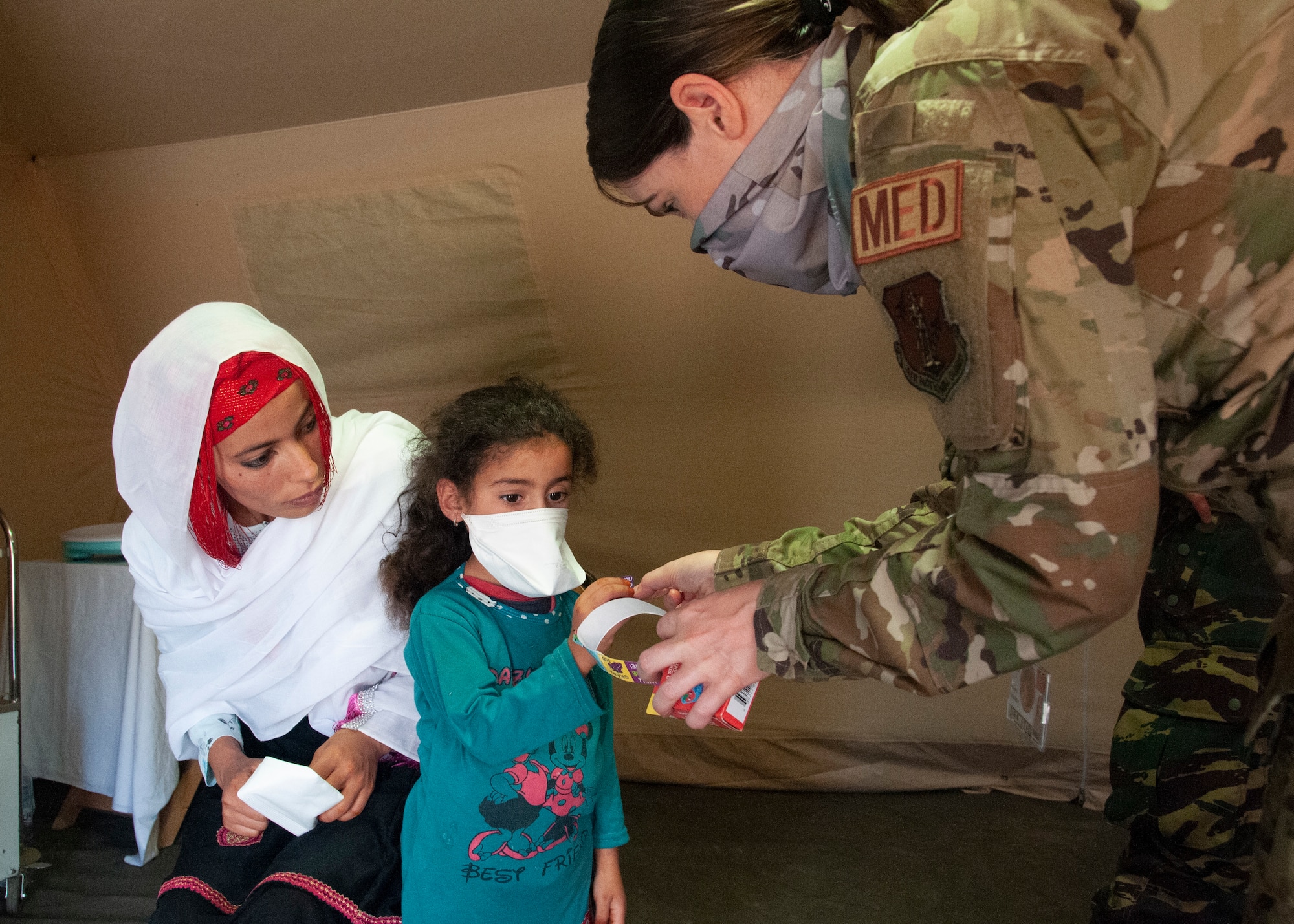 U.S. Air Force 1st Lt. Kimberly Hegeman, a nurse with the 151st Medical Group, gives a sticker to a child visiting the pediatric section of the military field hospital, June 7, 2021 in Tafraoute, Morocco during exercise African Lion 2021. The exercise is U.S. Africa Command’s largest, premier, joint, annual exercise hosted by Morocco, Tunisia, and Senegal. AL21 is a multi-domain, null-component, and multinational exercise, which employs a full array of mission capabilities with the goal to strengthen interoperability among participants. (U.S. Air National Guard photo by Tech. Sgt. Annie Edwards)