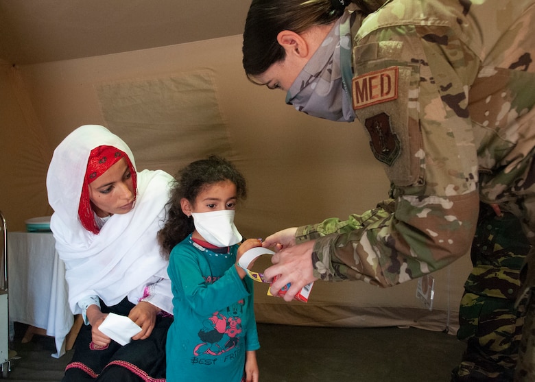 U.S. Air Force 1st Lt. Kimberly Hegeman, a nurse with the 151st Medical Group, gives a sticker to a child visiting the pediatric section of the military field hospital on June 7, 2021 in Tafraoute, Morocco during exercise African Lion 2021. African Lion 2021 is U.S. Africa Command's largest, premier, joint, annual exercise hosted by Morocco, Tunisia, and Senegal. AL21 is a multi-domain, null-component, and multinational exercise, which employs a full array of mission capabilities with the goal to strengthen interoperability among participants. (U.S. Air National Guard photo by Tech. Sgt. Annie Edwards)
